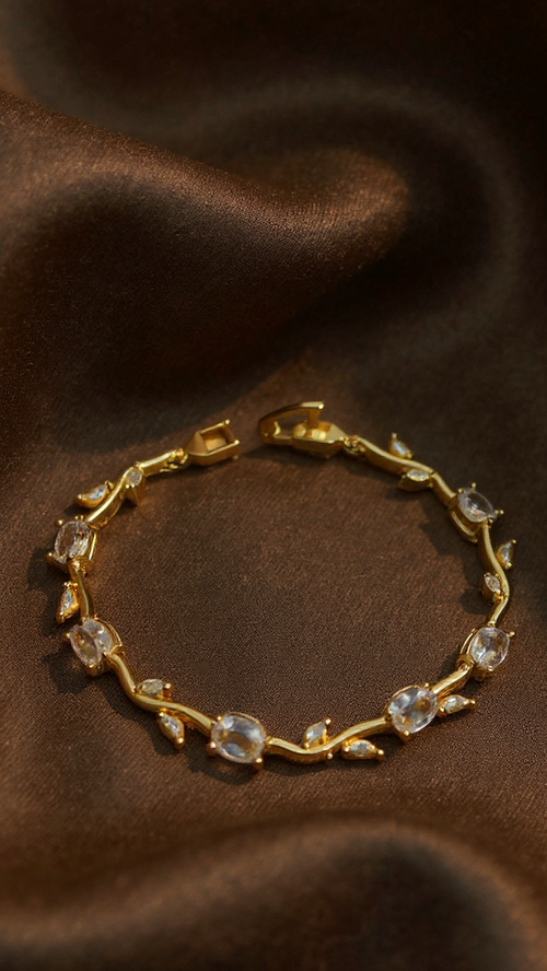 A gold vine-style bracelet with clear oval and marquise-cut stones, displayed on draped brown satin fabric. The image has an 'AI-generated' watermark in the bottom-left corner.